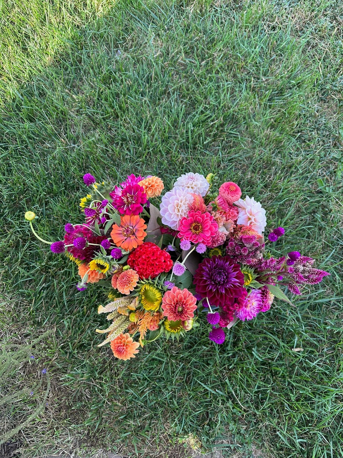 A round, garden-style bouquet of mixed summer flowers